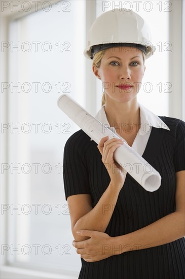 Female architect holding blueprints.