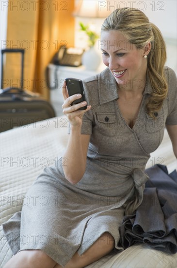 Woman texting in hotel room.