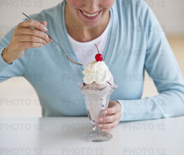 Woman eating ice cream sundae.