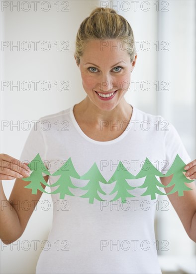 Woman holding cut out of trees.