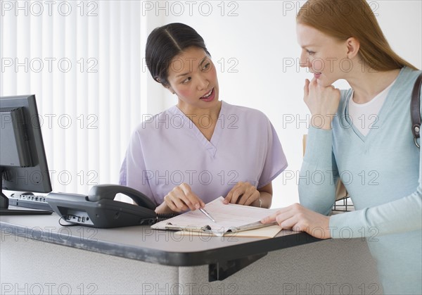 Nurse talking to patient in doctor's office.