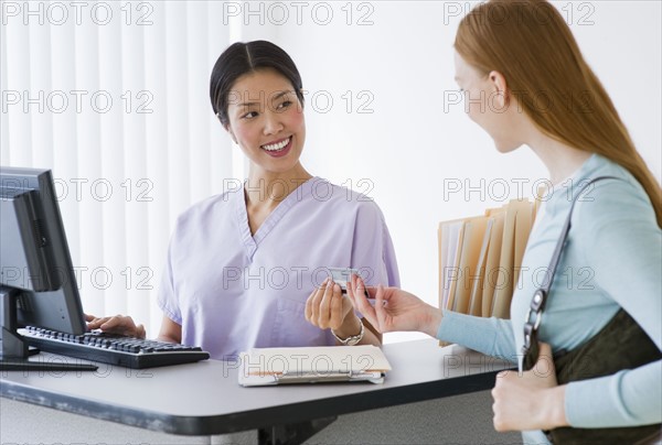 Nurse talking to patient in doctor's office.