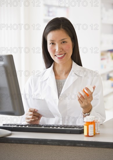 Pharmacist holding prescription medication.