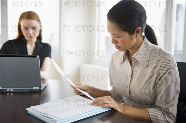 Businesswomen working in conference room.