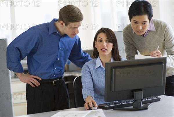 Office workers in cubicle.