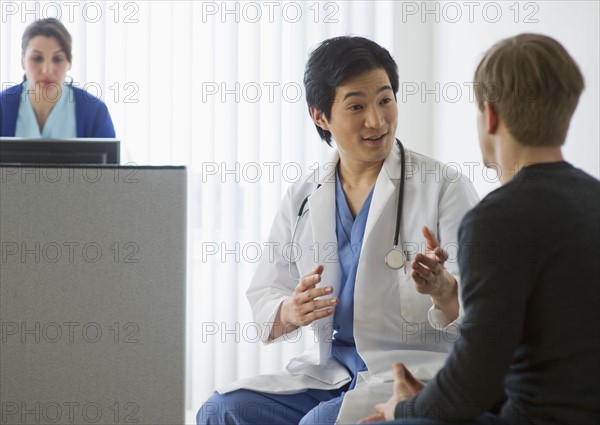 Doctor talking to patient in waiting room.