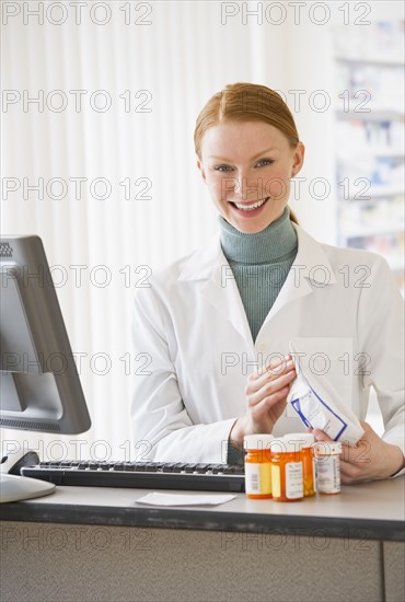 Pharmacist holding prescription medication.