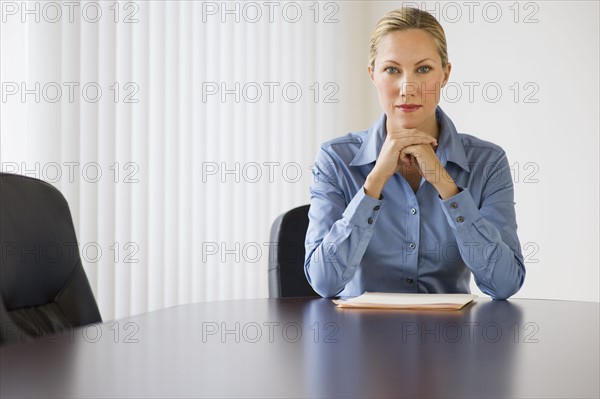 Businesswoman sitting at conference table.