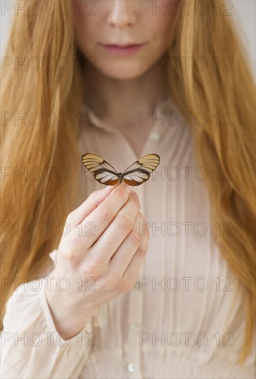 Woman holding butterfly.