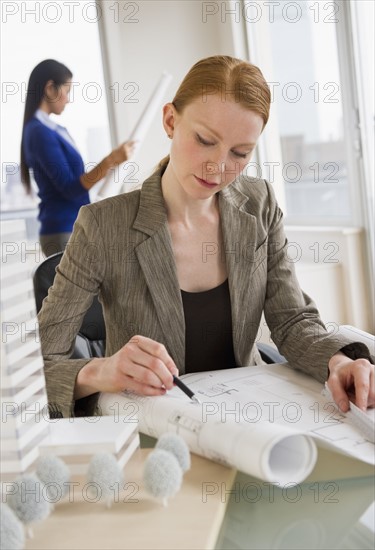 Female architect looking at blueprints.