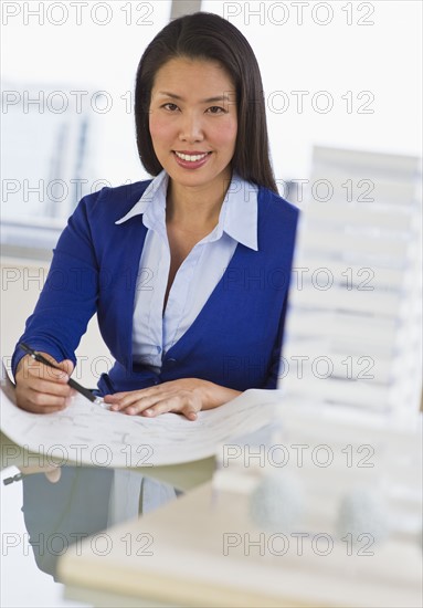 Female architect looking at blueprints.