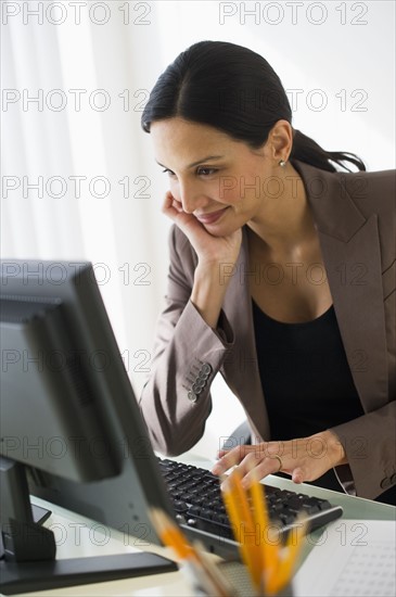 Pregnant businesswoman working on computer.