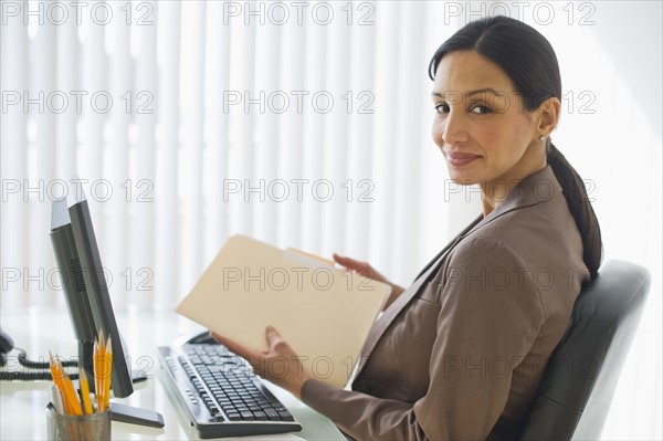 Pregnant businesswoman working at desk.