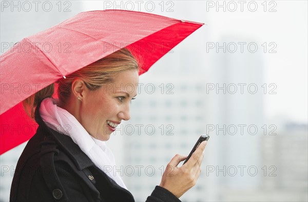 Woman texting on a rainy day.