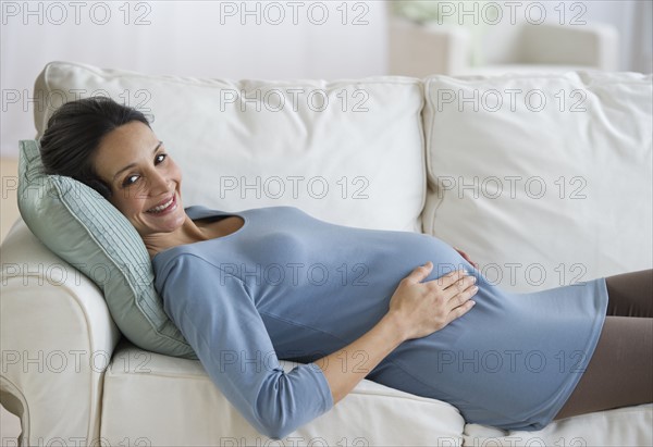 Pregnant woman resting on couch.