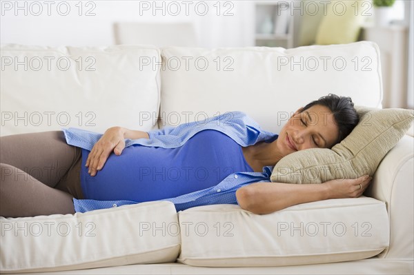 Pregnant woman napping on couch.