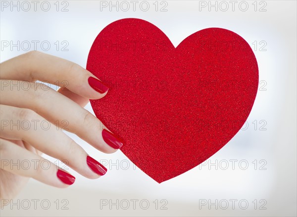 Hand holding red heart.