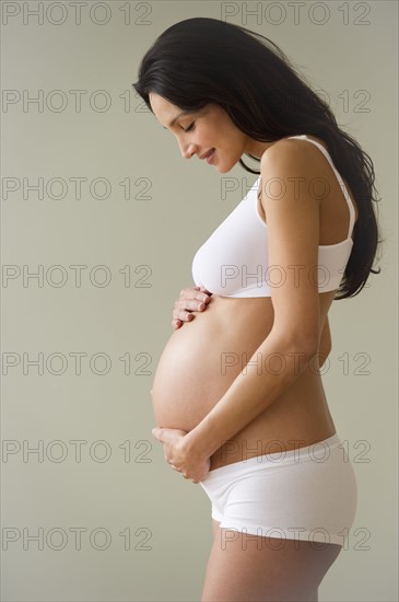 Pregnant woman holding her belly.