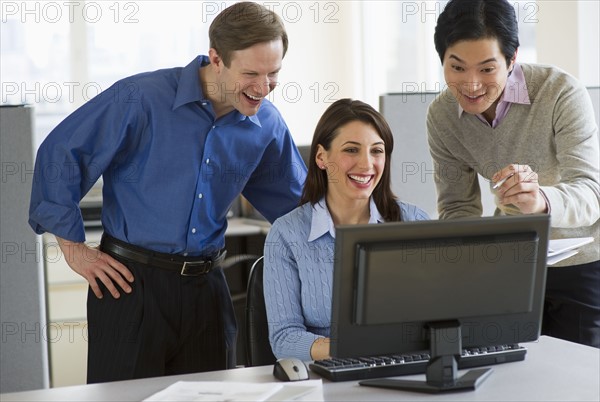 Office workers in cubicle.