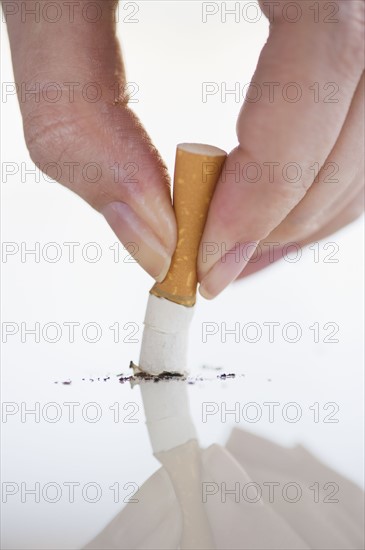 Hand putting out cigarette.