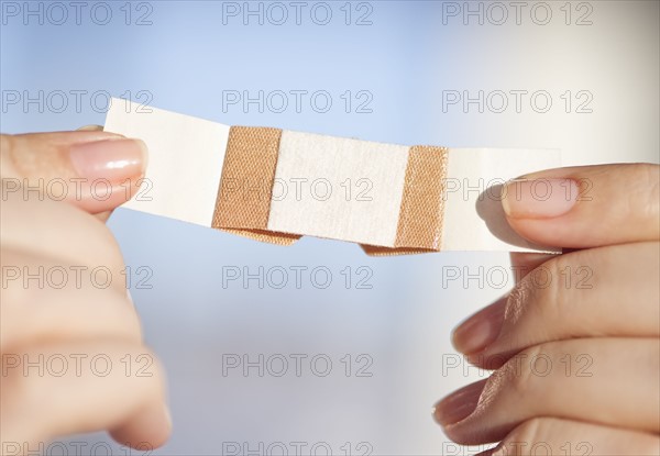 Hand holding band-aid.