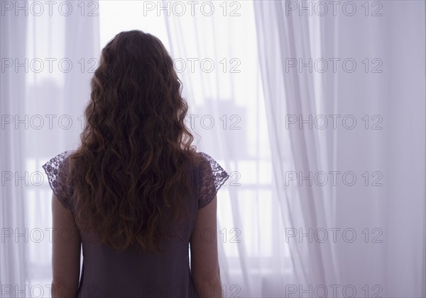 Woman looking out window.