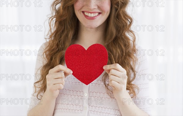 Woman holding a red heart.