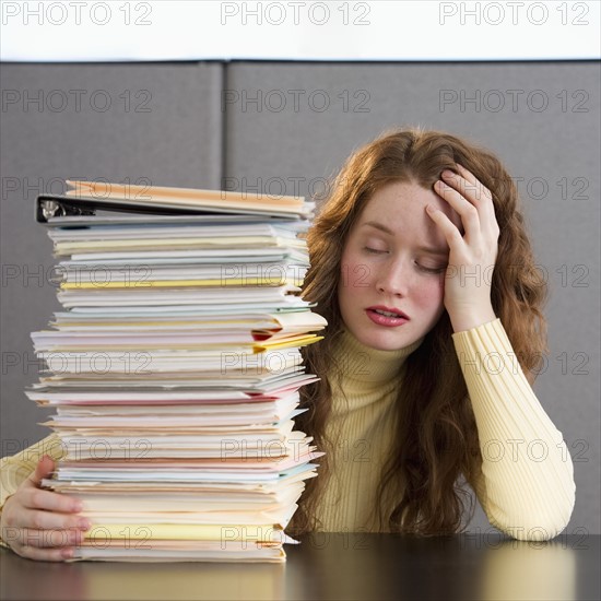 Overworked woman in cubicle.