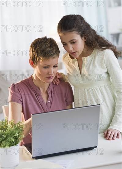 Mother helping daughter with her homework.