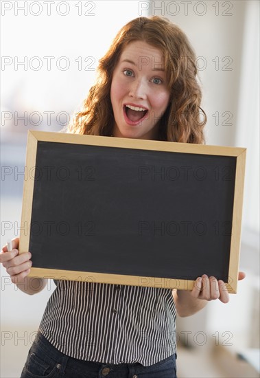 Woman holding a blank chalkboard.