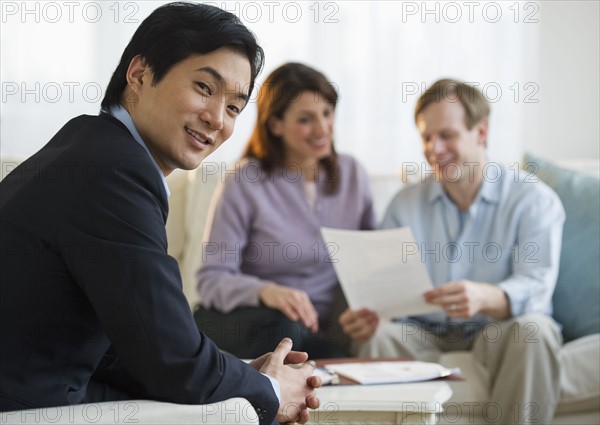 Financial planner and couple at home consultation.