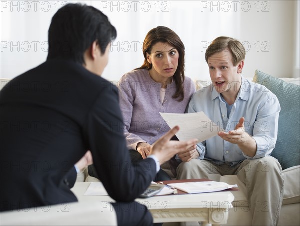 Financial planner talking to couple in their home.