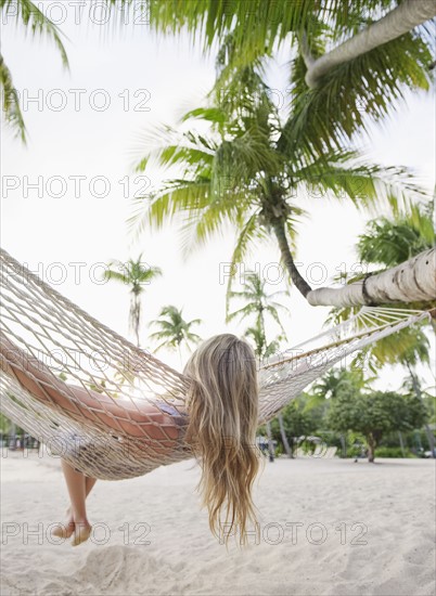 Blonde woman relaxing in hammock. Photographe : Jamie Grill