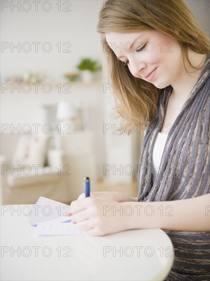 Woman writing a letter. Photographe : Jamie Grill