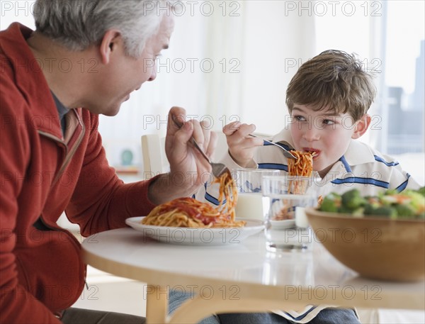 Father and son eating spaghetti. Photographe : Jamie Grill