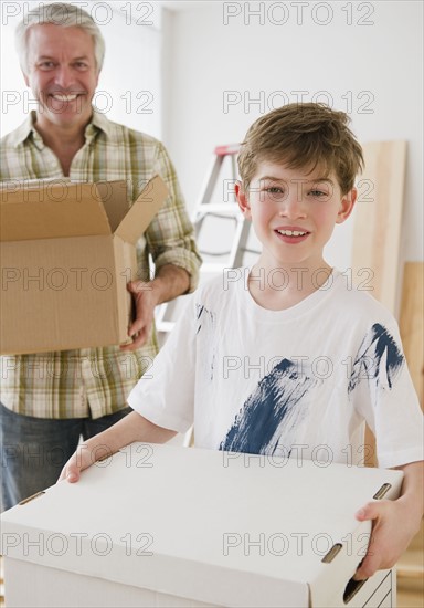 Father and son carrying moving boxes. Photographe : Jamie Grill