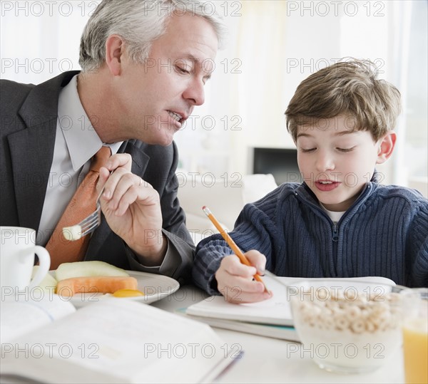 Father helping son with homework. Photographe : Jamie Grill