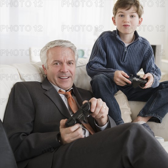 Father and son playing video game. Photographe : Jamie Grill
