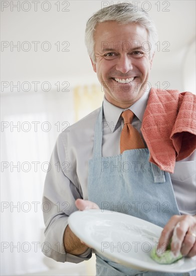 Father washing dishes. Photographe : Jamie Grill
