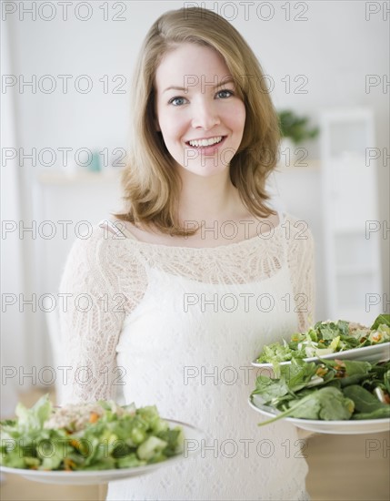 Woman carrying plates of salad. Photographe : Jamie Grill
