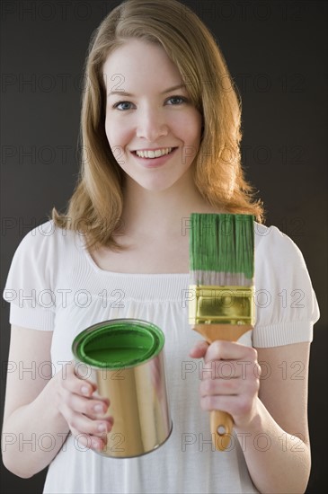 Woman holding green paint. Photographe : Jamie Grill