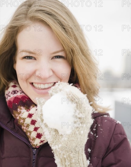 Woman holding a snowball. Photographe : Jamie Grill