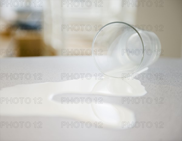 Spilt glass of milk. Photographe : Jamie Grill