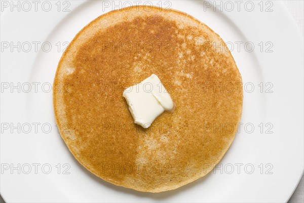 Pancake and butter on plate. Photographe : Kristin Lee