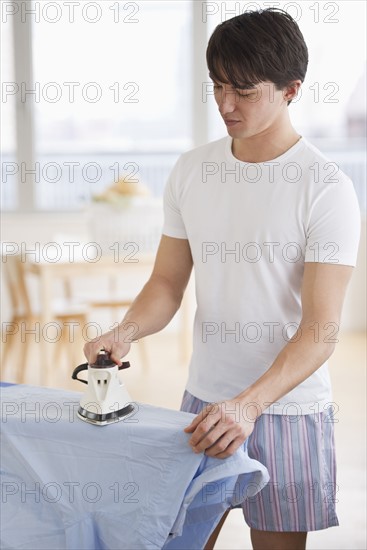 Man ironing his shirt. Photographe : Daniel Grill