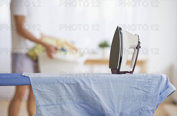 Iron and shirt on ironing board. Photographe : Daniel Grill
