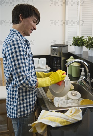 Man washing dishes. Photographe : Daniel Grill