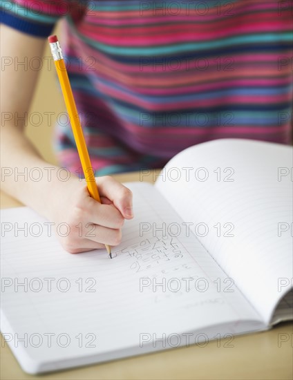 Student writing in notebook. Photographe : Daniel Grill