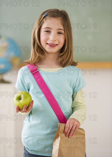 Student in classroom holding lunch. Photographe : Daniel Grill