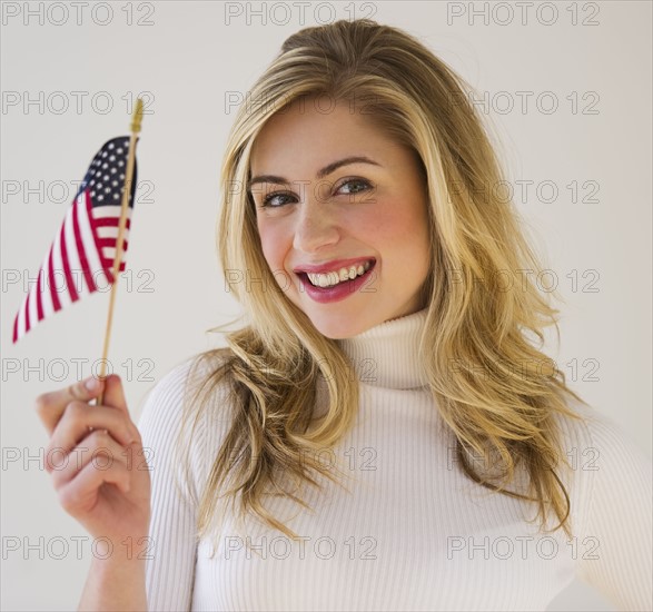 Young woman holding American flag. Photographe : Daniel Grill